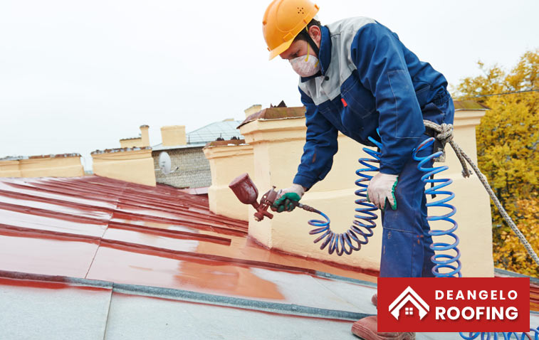 Professional applying waterproof coatings on a metal roof